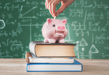 Piggy bank on top of books.