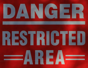 A red danger sign that says restricted area.