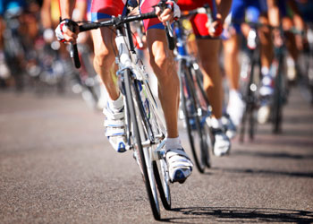 Athletes race on bikes.