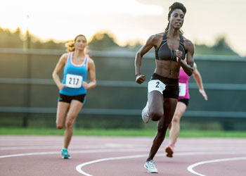 Athletes sprint around a track.