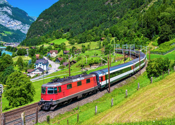 Passenger train amongst mountains in Switzerland.