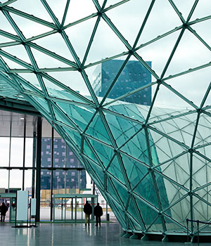 A building with curved glass walls made up of triangles.